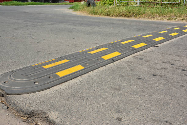 istock Traffic safety speed bump on an asphalt road. Speed bumps or speed breakers are traffic calming devices. 1214444691
