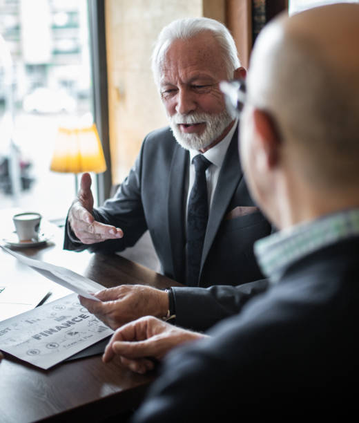 istock Old businessman looking at project stock photo 1214447512
