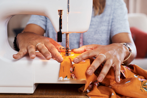 Cropped shot of an unrecognizable woman making a garment at home