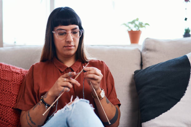Knitting is like a meditation session Cropped shot of a young woman knitting while relaxing at home knitting needle photos stock pictures, royalty-free photos & images
