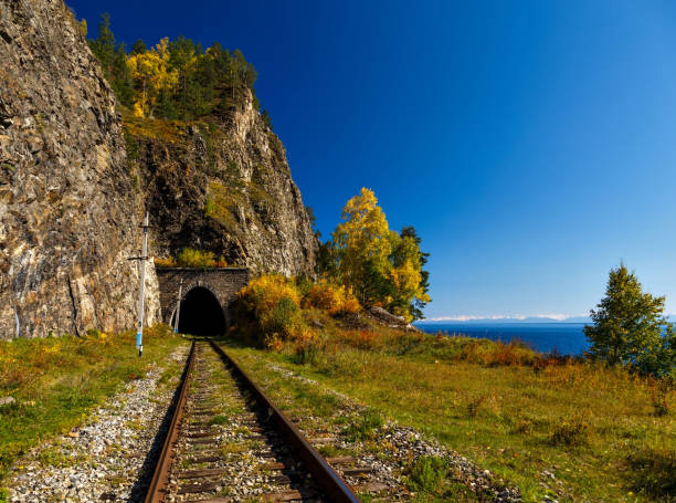 Old historical railway with tunnel at Baikal lake with cliffs at sunny day with blue sky in September