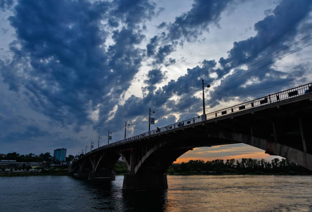 Old bridge with arches over Angara river in Irkutsk city after sunset wtih blue clouds