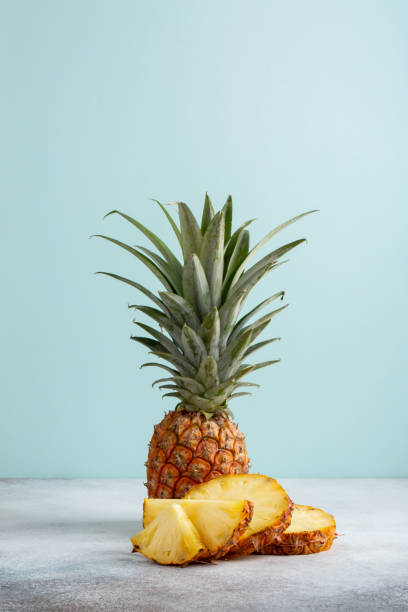 istock Whole and sliced pineapple on pastel blue background. Copy space. 1214452460