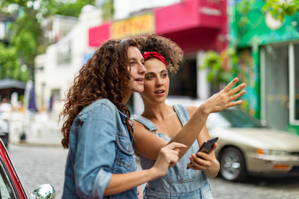 Tourists in Buenos Aires Two young women are standing on a street in Buenos Aires. They are waiting for a crowdsourced taxi. jeans shorts women latin american and hispanic ethnicity stock pictures, royalty-free photos & images