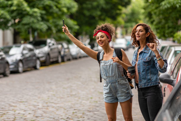 Tourists in Buenos Aires Two young women are standing on a street in Buenos Aires. They are waiting for a crowdsourced taxi. jeans shorts women latin american and hispanic ethnicity stock pictures, royalty-free photos & images