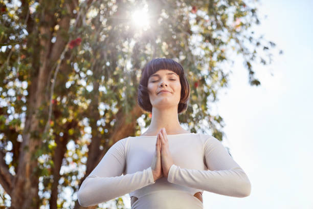 istock Smiling young woman meditating outside in the mountain pose 1214453720