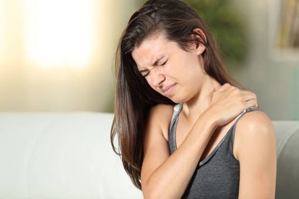 自宅で肩の痛みを苦しめている女の子 - arthritis osteoporosis pain backache ストックフォトと画像