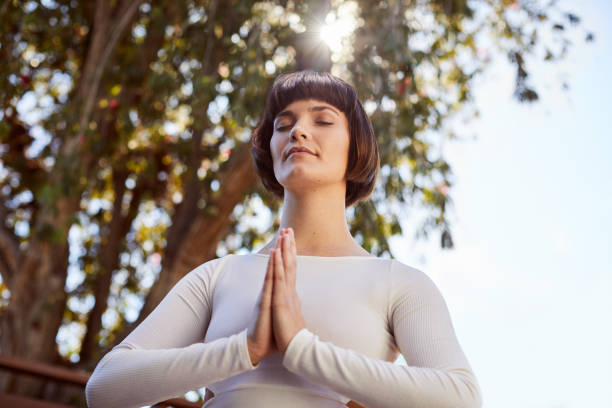 istock Young woman meditating outside in the mountain pose 1214454821