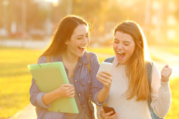 istock Excited students checking exam results on phone outside 1214455352