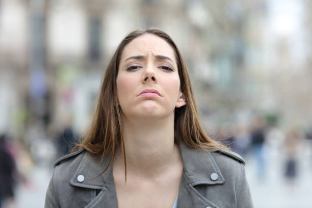 istock Disappointed woman looking at camera on street 1214455398