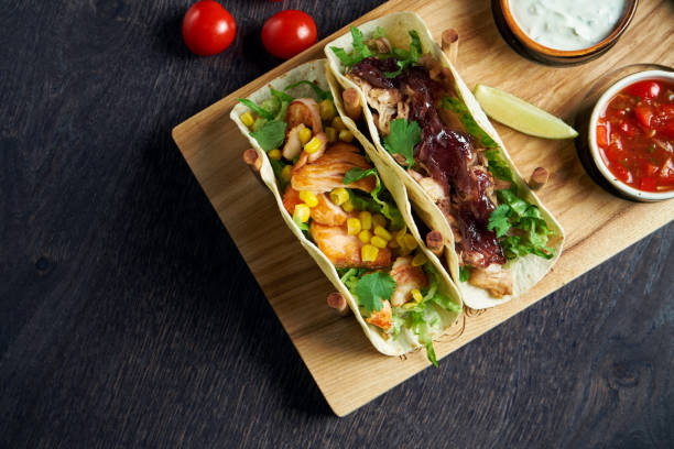 istock Appetizing Mexican tacos with fried chicken and stewed beef, cabbage, onions and parsley in special stands. Traditional mexican cuisine 1214455567
