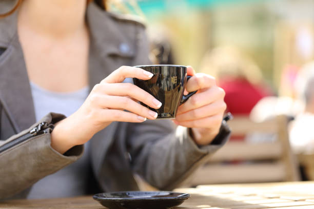istock Woman hands holding a coffee cup on a cafe terrace 1214455574