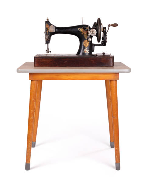 istock Antique, vintage sewing machine on an old table, isolated on white 1214455688
