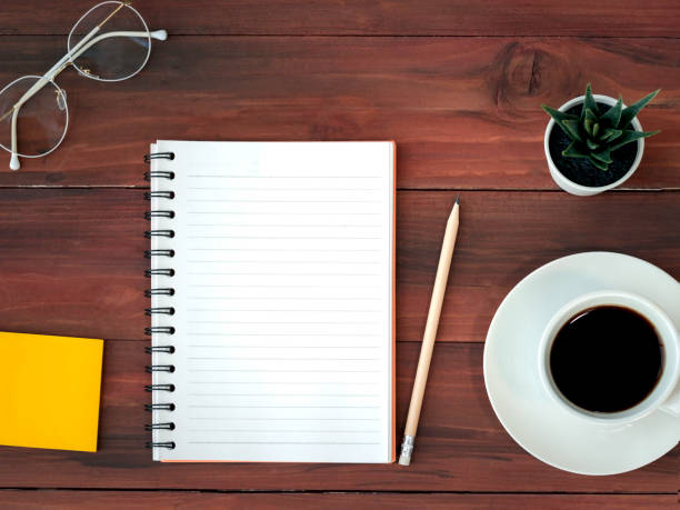 istock Wooden office table workspace from top view above with copy space, working desk with mix of office supplies and cup of coffee 1214456948