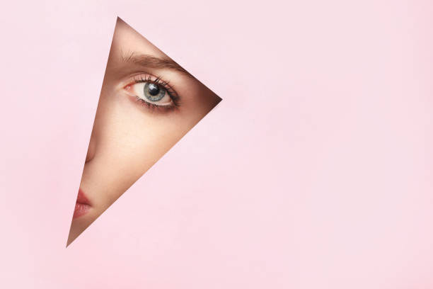 istock Painted woman eye into paper hole 1214457117