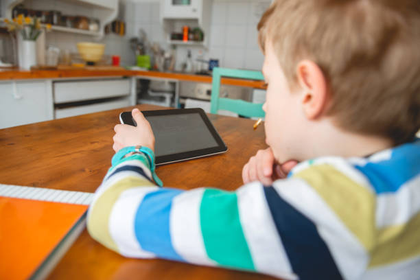 istock Young Boy looking at digital tablet, staying at home 1214457347