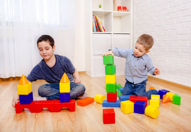 istock Attractive children playing with constructor on floor at home 1214458751