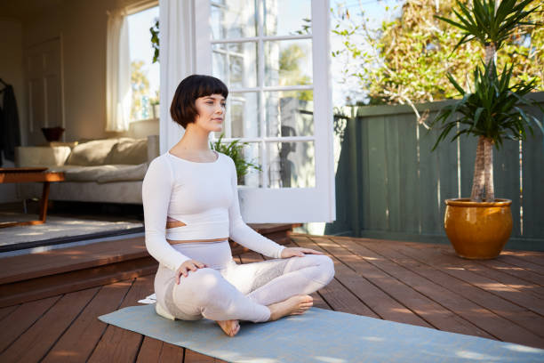 istock Young woman practicing yoga alone on her patio 1214459163