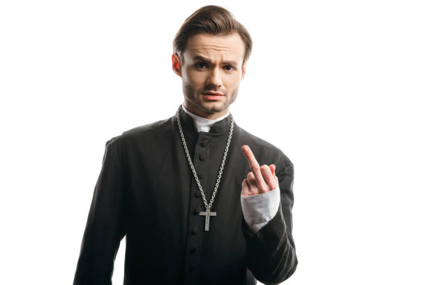 istock displeased catholic priest showing middle finger while looking at camera isolated on white 1214461891