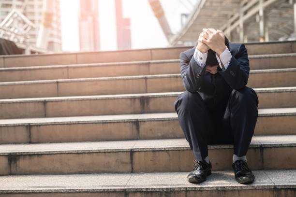 istock image of young man sitting on a stairway,depression 1214461933