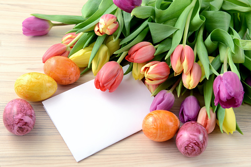 Happy easter with eggs and tulips. Paper copy space.