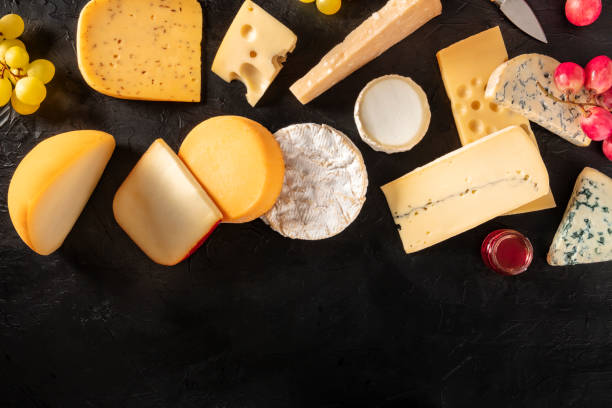 Many different types of cheese, shot from the top on a black background with a place for text Many different types of cheese, shot from the top on a black background with a place for text cheese goat cheese gourmet food stock pictures, royalty-free photos & images