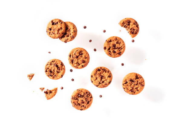 schokoladen-chip-cookies, fliegen auf weißem hintergrund, von oben geschossen - drop cookies stock-fotos und bilder
