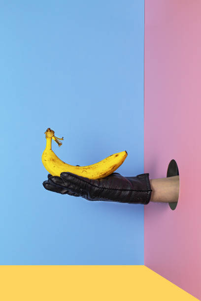 istock Hand holding Yellow Banana on a colorful background with copy space. 1214467867