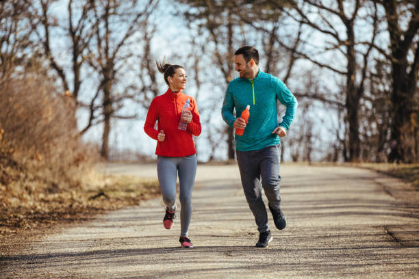 istock Athletic couple jogging in nature 1214469206
