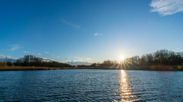 istock Blue sky and sunset behind a lake 1214469549