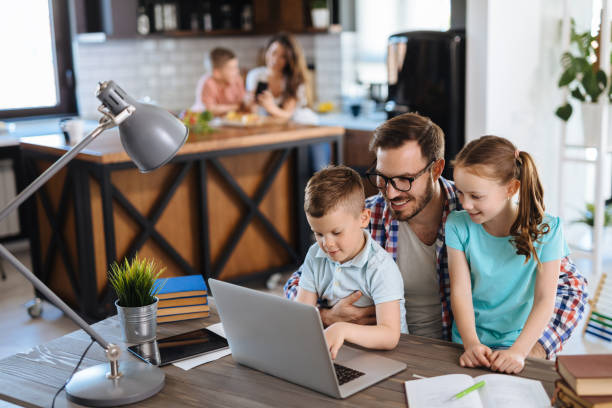 istock Kids having fun at home, playing with their father, using laptop 1214471355