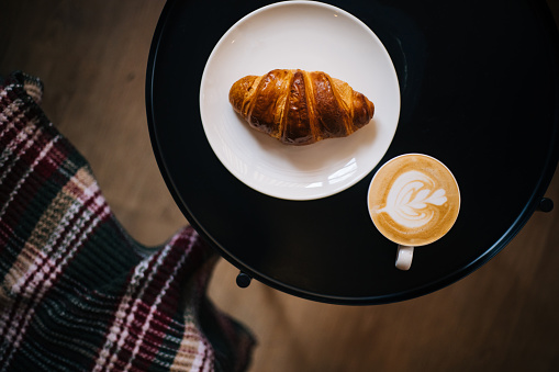 Coffee and croissant in cozy place