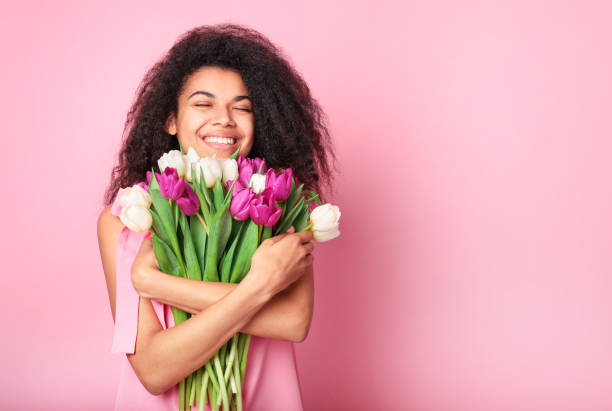 istock Young african woman with tulips bouquet 1214473093