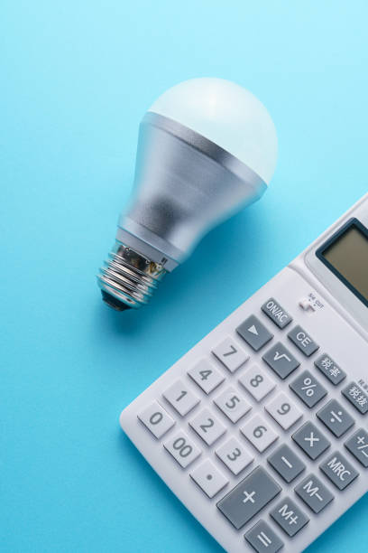 istock Calculator and led light bulb isolated on color background 1214475169