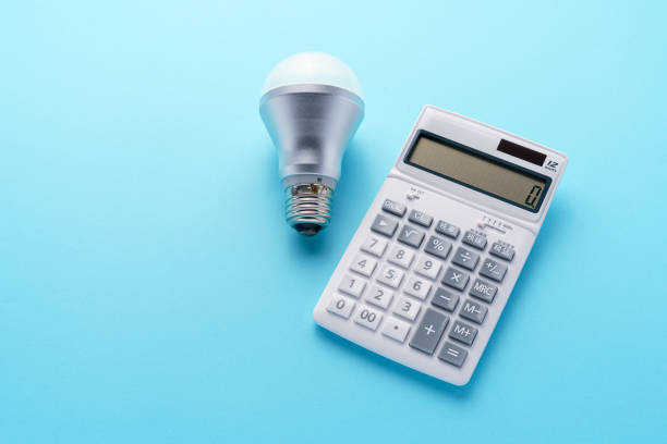 istock Calculator and led light bulb isolated on color background 1214475199