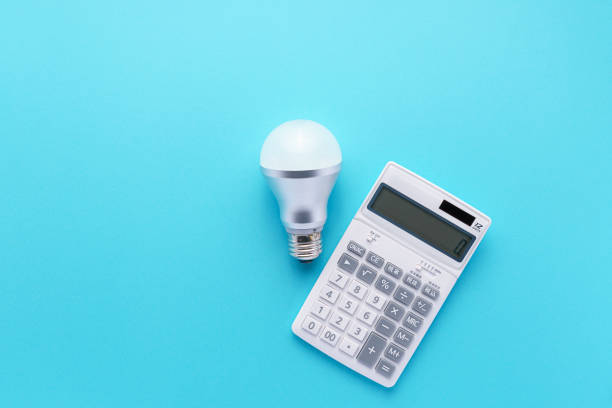istock Calculator and led light bulb isolated on color background 1214475215
