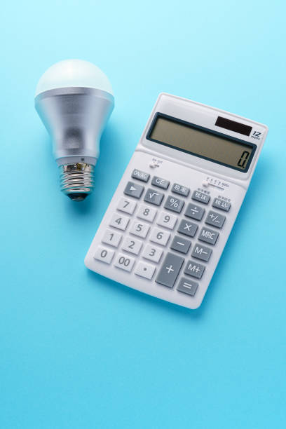 istock Calculator and led light bulb isolated on color background 1214475240