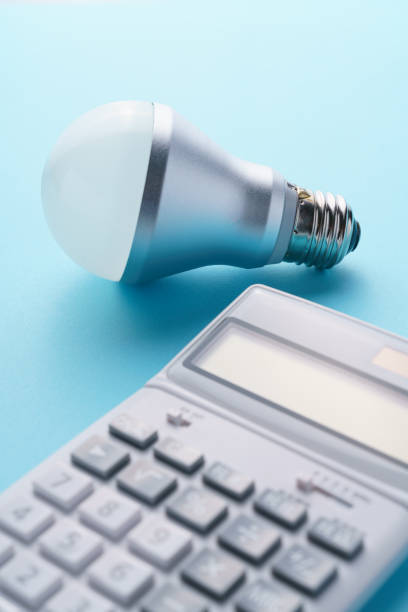 istock Calculator and led light bulb isolated on color background 1214475277