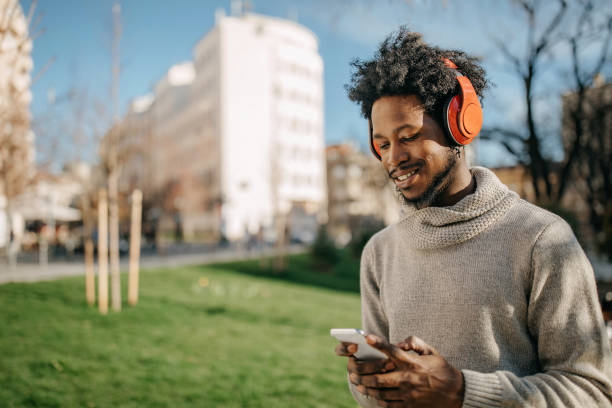 istock Young man walking and listening music 1214475355