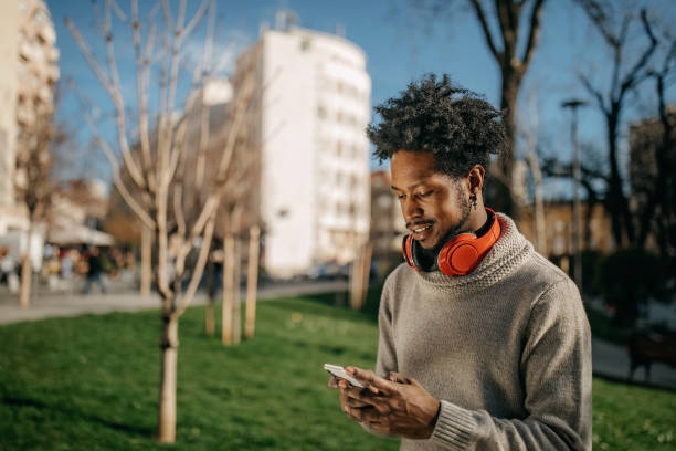 istock Young man walking and listening music 1214475359