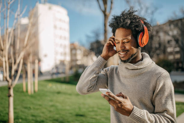 istock Young man walking and listening music 1214475407