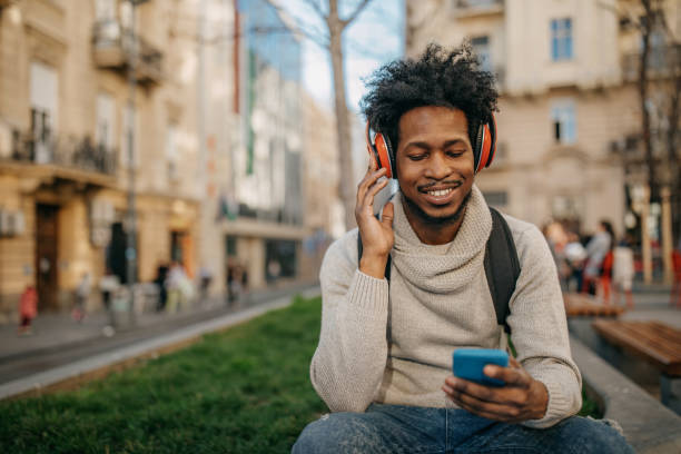 istock Young man walking and listening music 1214475469