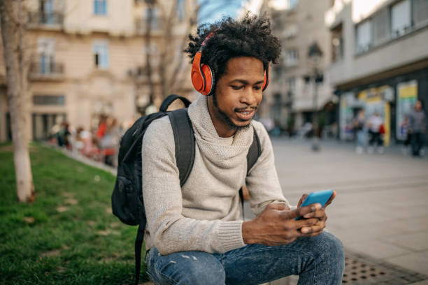 istock Young man walking and listening music 1214475718
