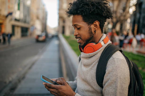 istock Young man walking and listening music 1214475889