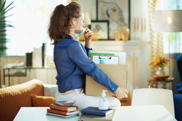 istock trendy woman with mask transporting stuff to home office 1214476535