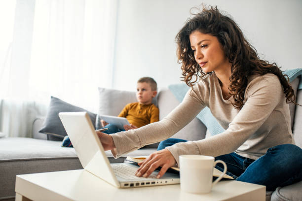 istock Shot of a boy playing while his mother is working on a computer. 1214476733