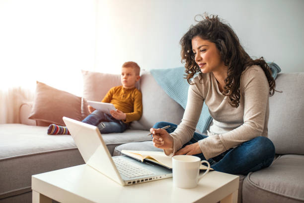 istock Shot of a boy playing while his mother is working on a computer. 1214477383