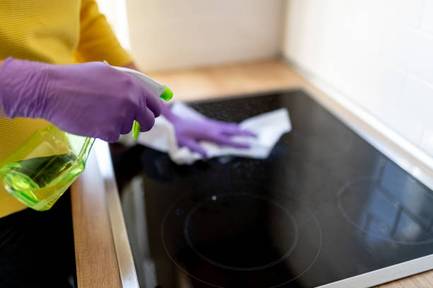 istock Hands in gloves disinfecting stove top 1214477640