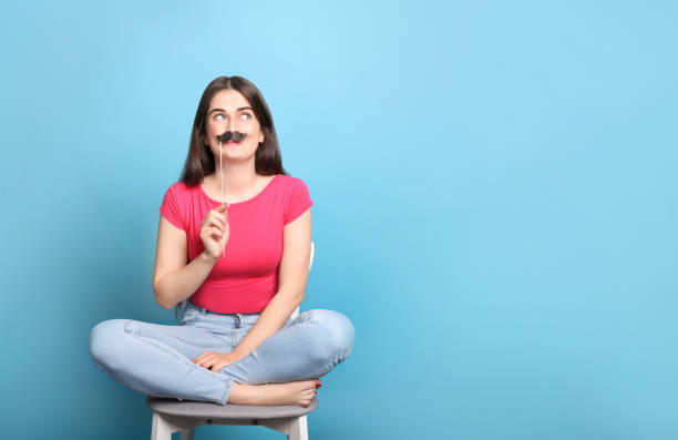 jeune femme posant avec la moustache de papier - fake mustache photos et images de collection