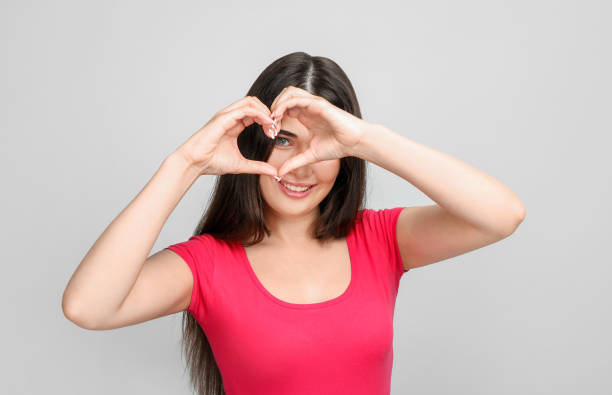 istock Young woman making heart gesture 1214478407